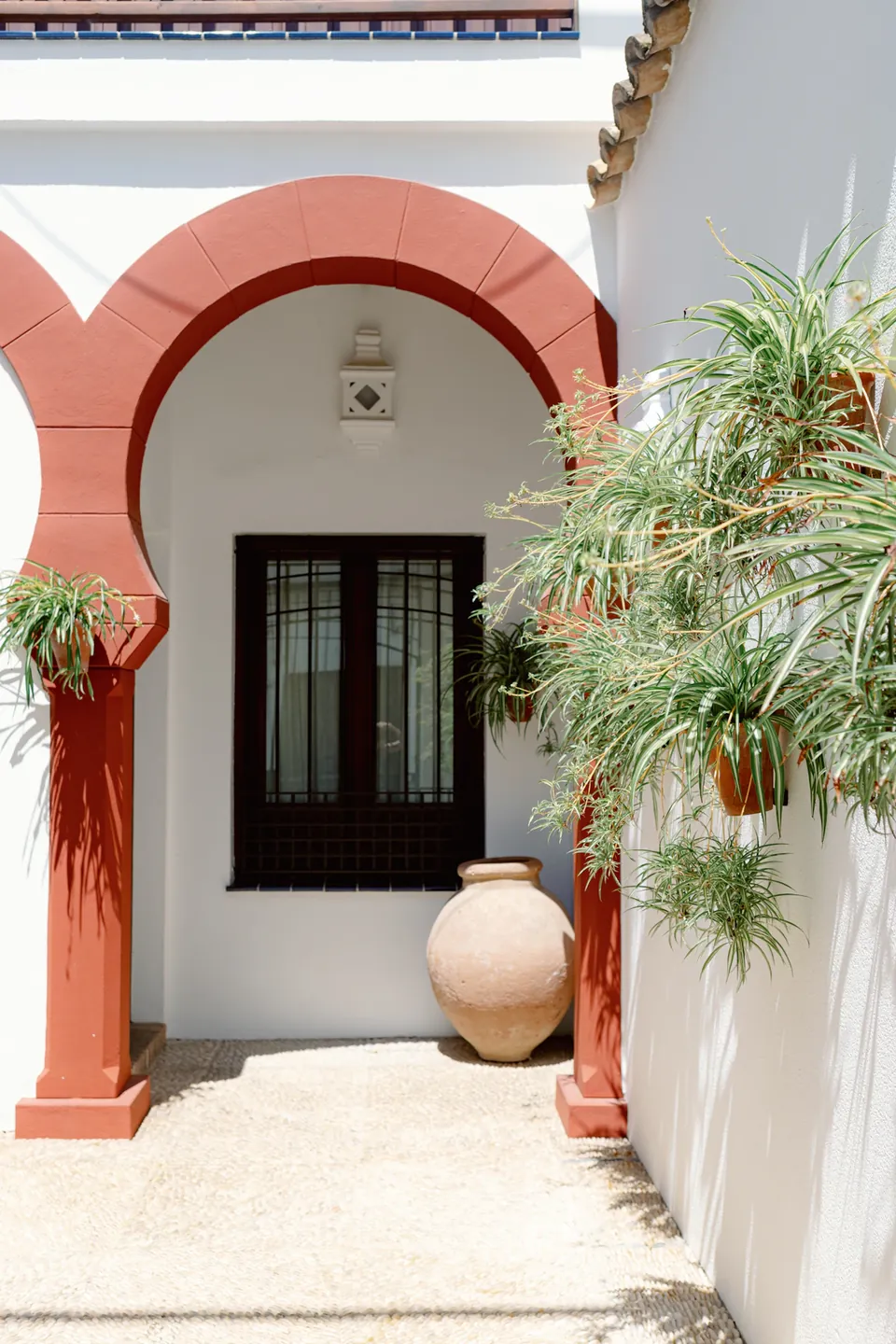 Sunlight on a terracotta arch and white courtyard walls in Córdoba